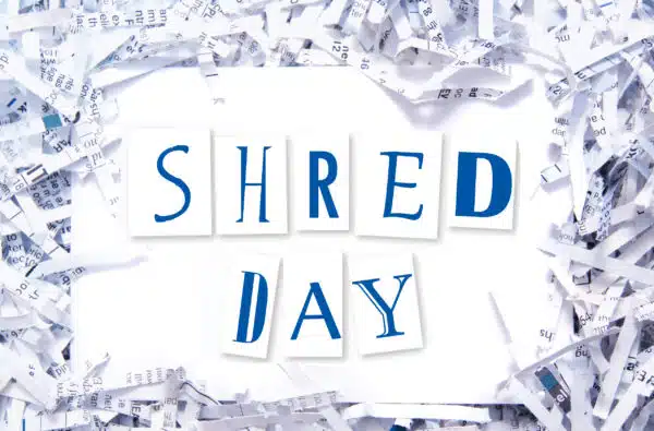 Shred Day text on plain white background framed by shredded pieces of paper