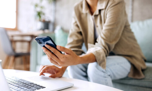 Young unrecognisable woman using phone working from home