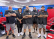 team of barbers standing in a line with arms folded