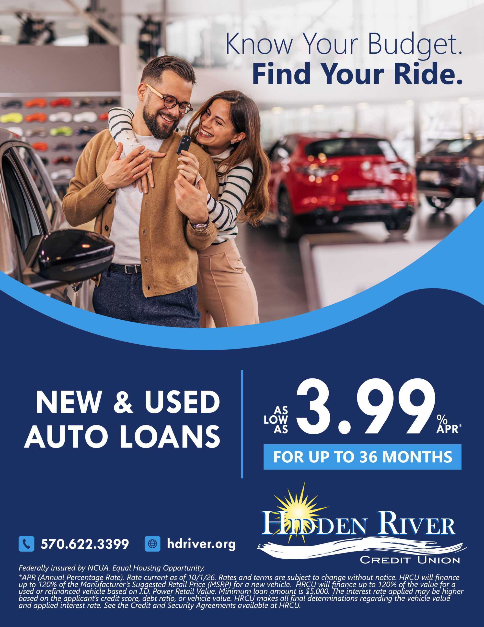 A couple at a car dealership holding car keys and smiling.