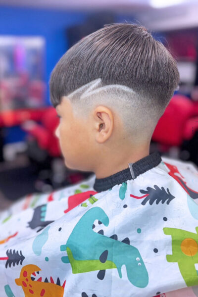young man with head turned away and a freshly cut look with fading and a zig zag design in his hair